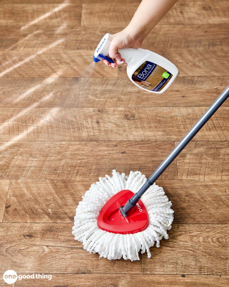 caring for hardwood floors caring for hardwood floors - spraying Bona floor cleaner on a wood floor in front of a mop